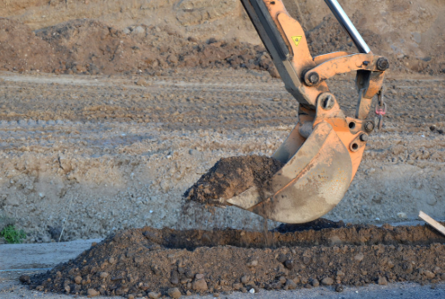Close up of excavator taking a scoop of dirt from the ground